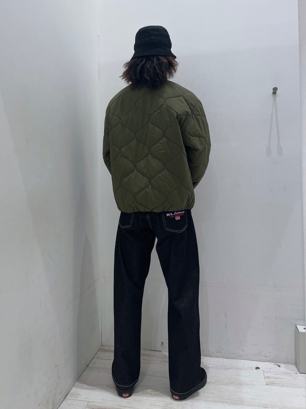 グリーン系のブルゾン、ブラック系のその他パンツ、ブラック系のハットを着用したメンズの秋コーディネートの3枚目の写真