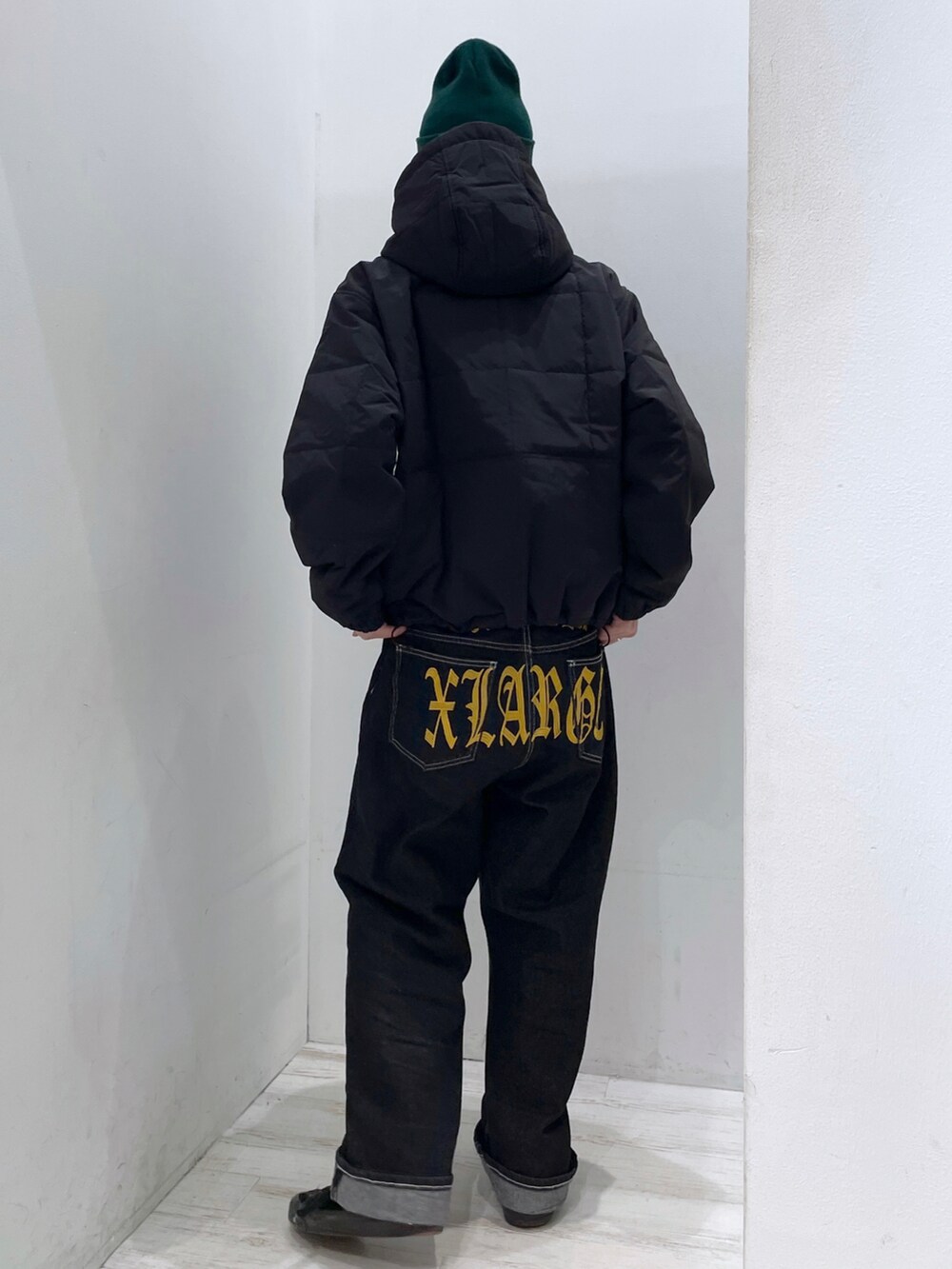 ブラック系のナイロンジャケット、ブラック系のデニムパンツ、グリーン系のニットキャップ/ビーニーを着用したメンズの秋コーディネートの2枚目の写真