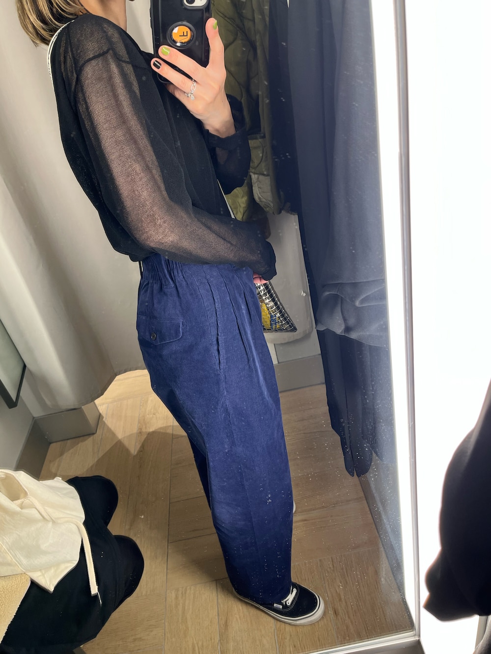 グリーン系のミリタリージャケット、ブラック系のニット/セーター、ブラック系のショルダーバッグを着用したレディースの冬コーディネートの2枚目の写真