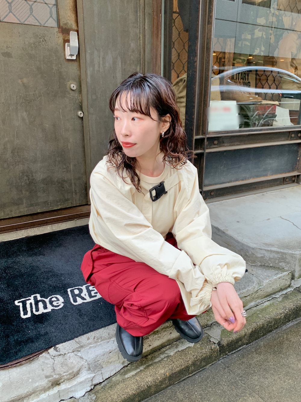 レッド系のカーゴパンツ、ホワイト系のカーディガン/ボレロを着用したレディースの冬コーディネートの2枚目の写真