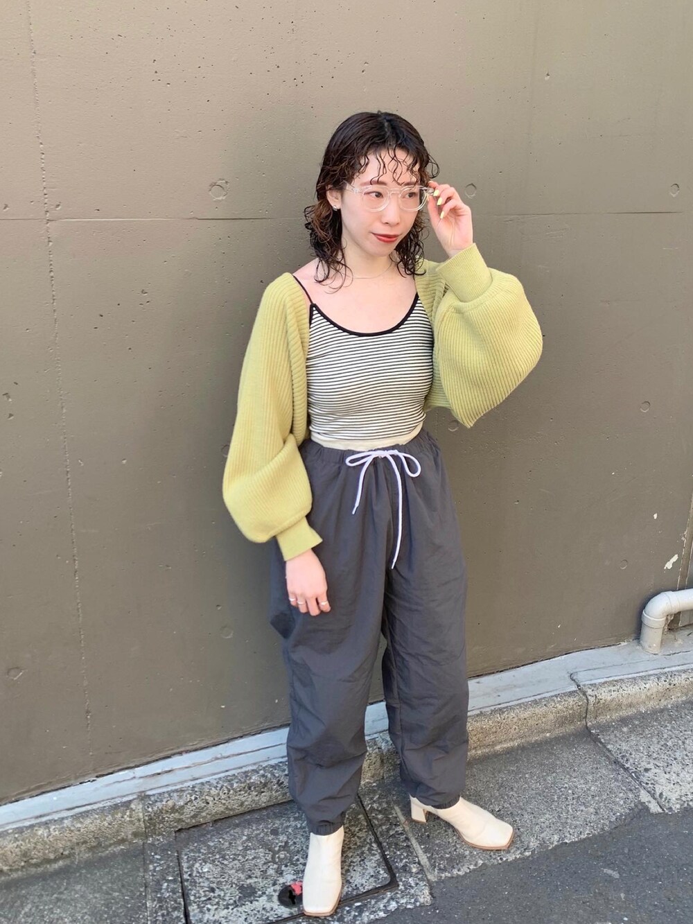 グリーン系のカーディガン/ボレロ、グレー系のその他パンツ、ブラック系のメガネを着用したレディースの冬コーディネートの3枚目の写真