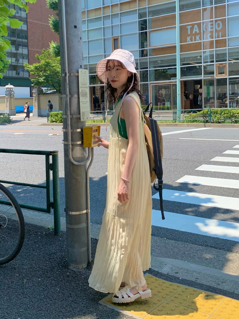 ホワイト系のワンピース、ベージュ系のバックパック/リュック、ホワイト系のサンダルを着用したレディースの夏コーディネートの3枚目の写真