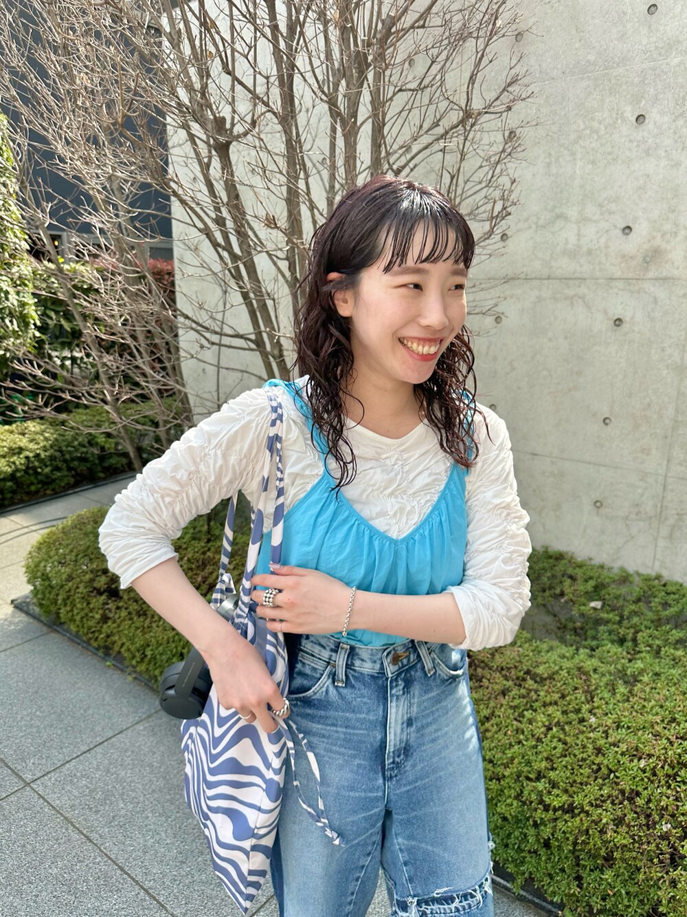 ホワイト系のTシャツ/カットソー、ブルー系のトートバッグを着用したレディースの春コーディネートの2枚目の写真