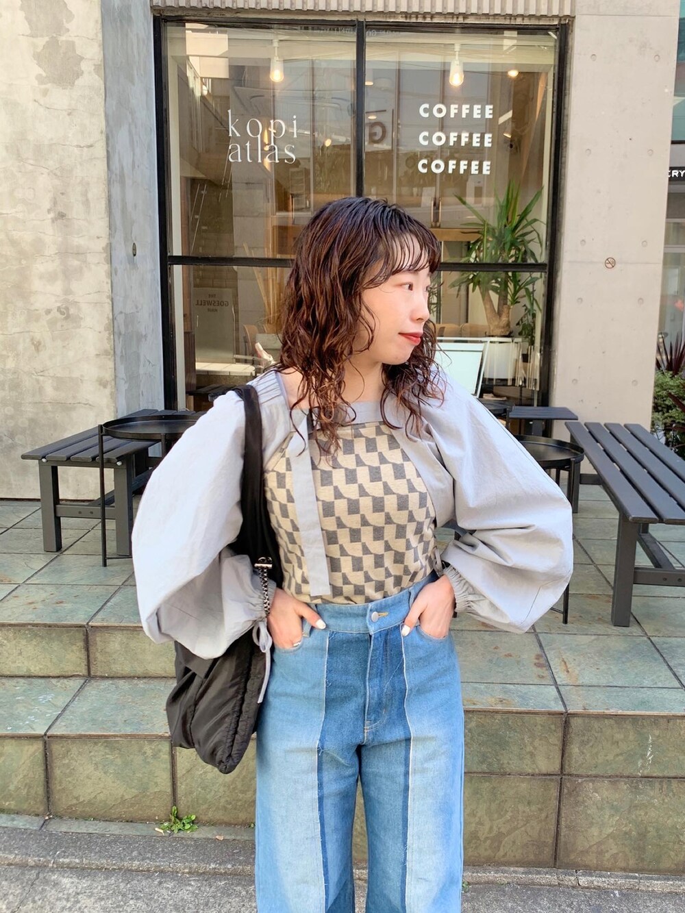 ブラック系のトートバッグ、ブルー系のカーディガン/ボレロを着用したレディースの冬コーディネートの3枚目の写真