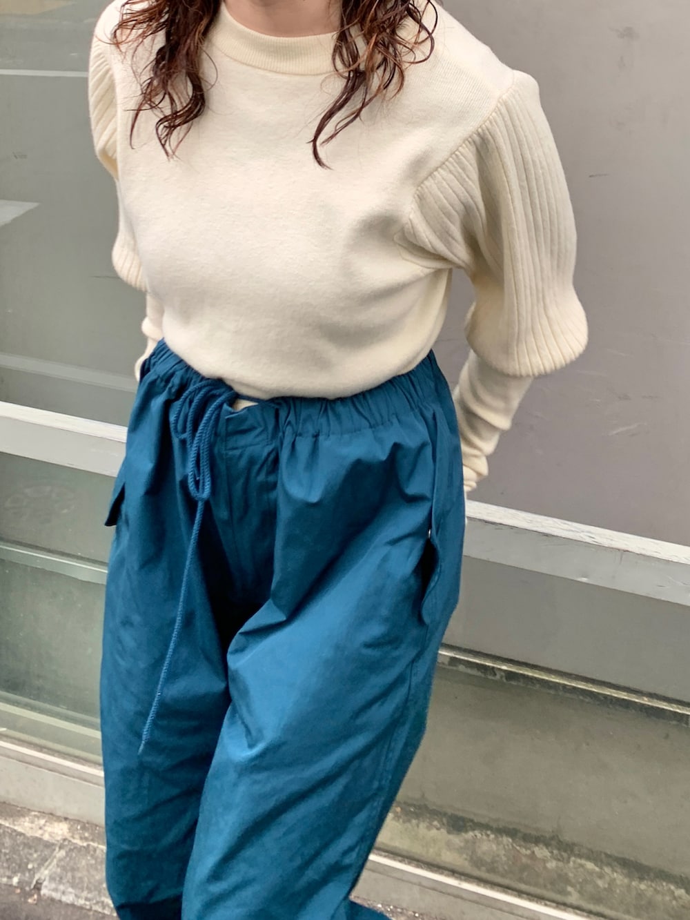 ブラック系のダウンジャケット/コート、ブルー系のカーゴパンツ、ホワイト系のカーディガン/ボレロを着用したレディースの秋コーディネートの3枚目の写真