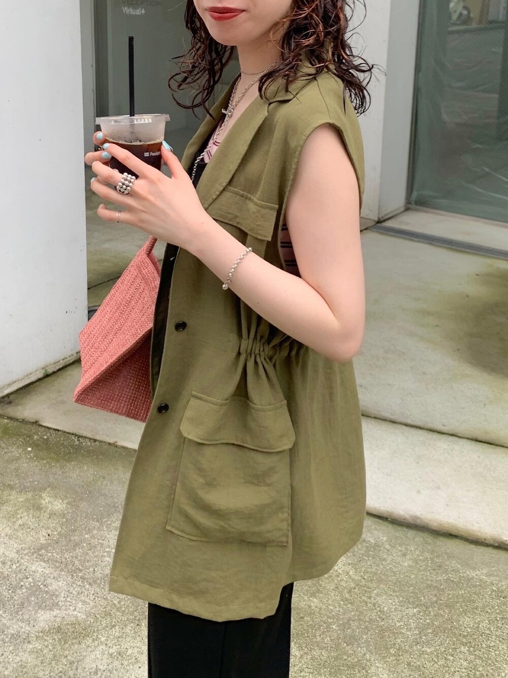 グリーン系のベスト、ピンク系のトートバッグ、ピンク系のTシャツ/カットソーを着用したレディースの夏コーディネートの3枚目の写真