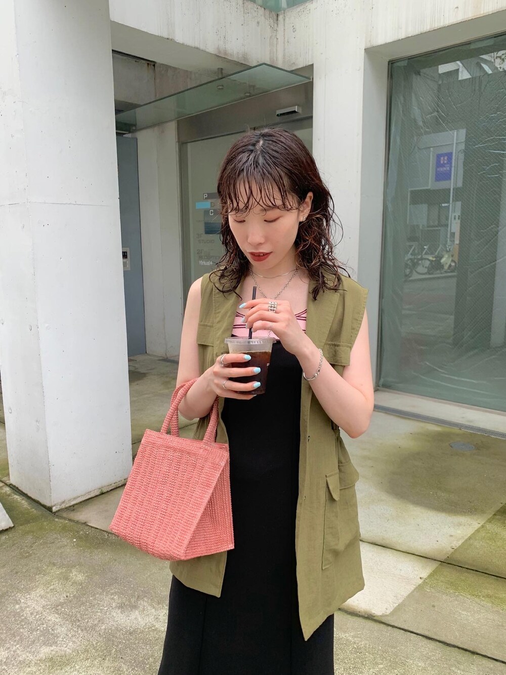 グリーン系のベスト、ピンク系のトートバッグ、ピンク系のTシャツ/カットソーを着用したレディースの夏コーディネートの2枚目の写真