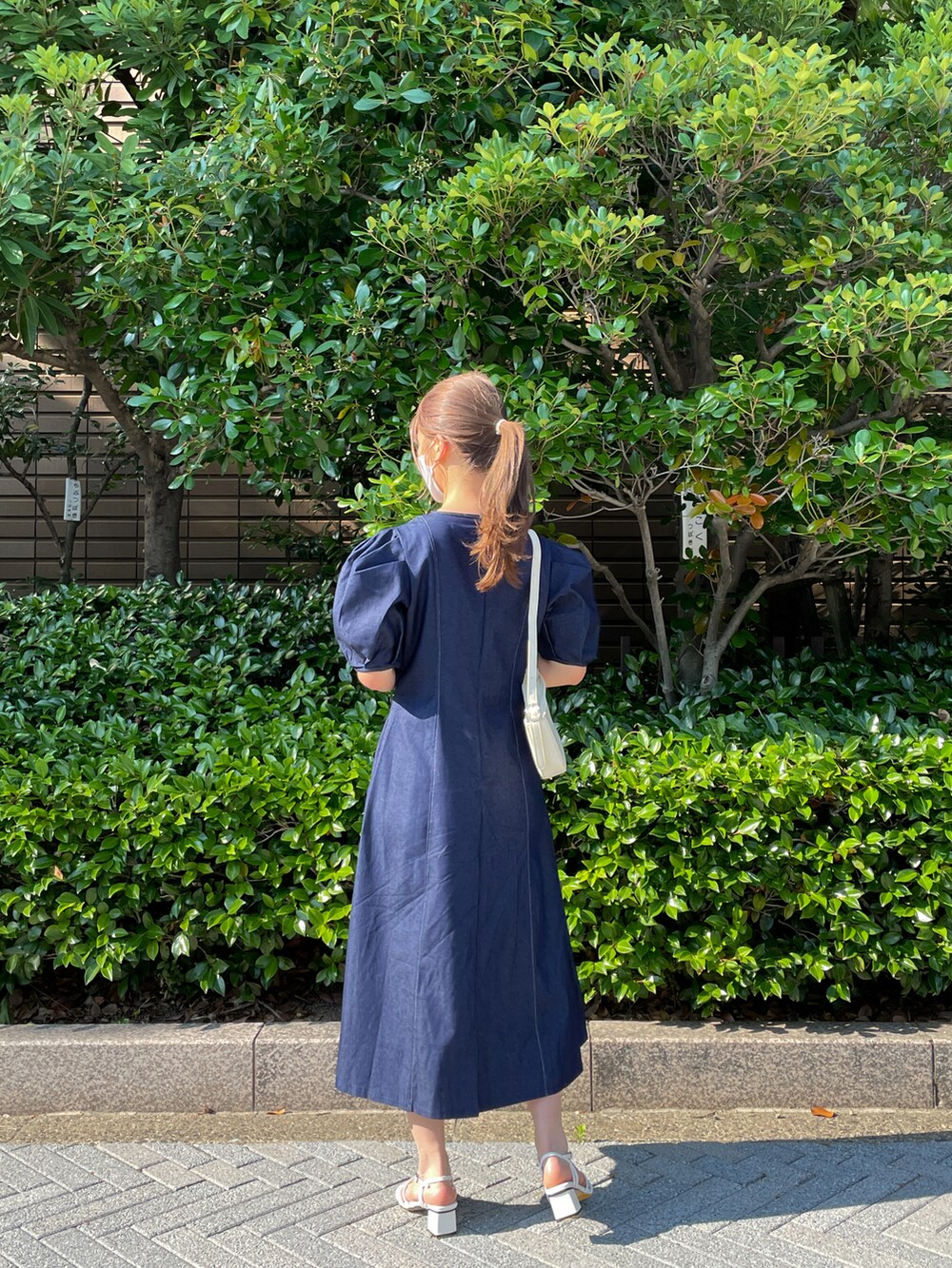 ブルー系のワンピース、ホワイト系のショルダーバッグ、ホワイト系のサンダルを着用したレディースの夏コーディネートの2枚目の写真