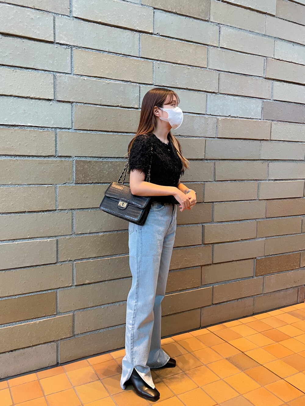 ブルー系のデニムパンツ、ブラック系のシャツ/ブラウス、ブラック系のブーツを着用したレディースの秋コーディネートの2枚目の写真