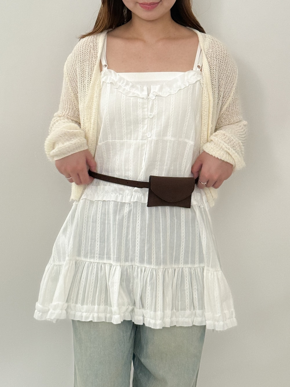 ホワイト系のワンピース、ブルー系のデニムパンツ、ホワイト系のニット/セーターを着用したレディースの夏コーディネートの3枚目の写真