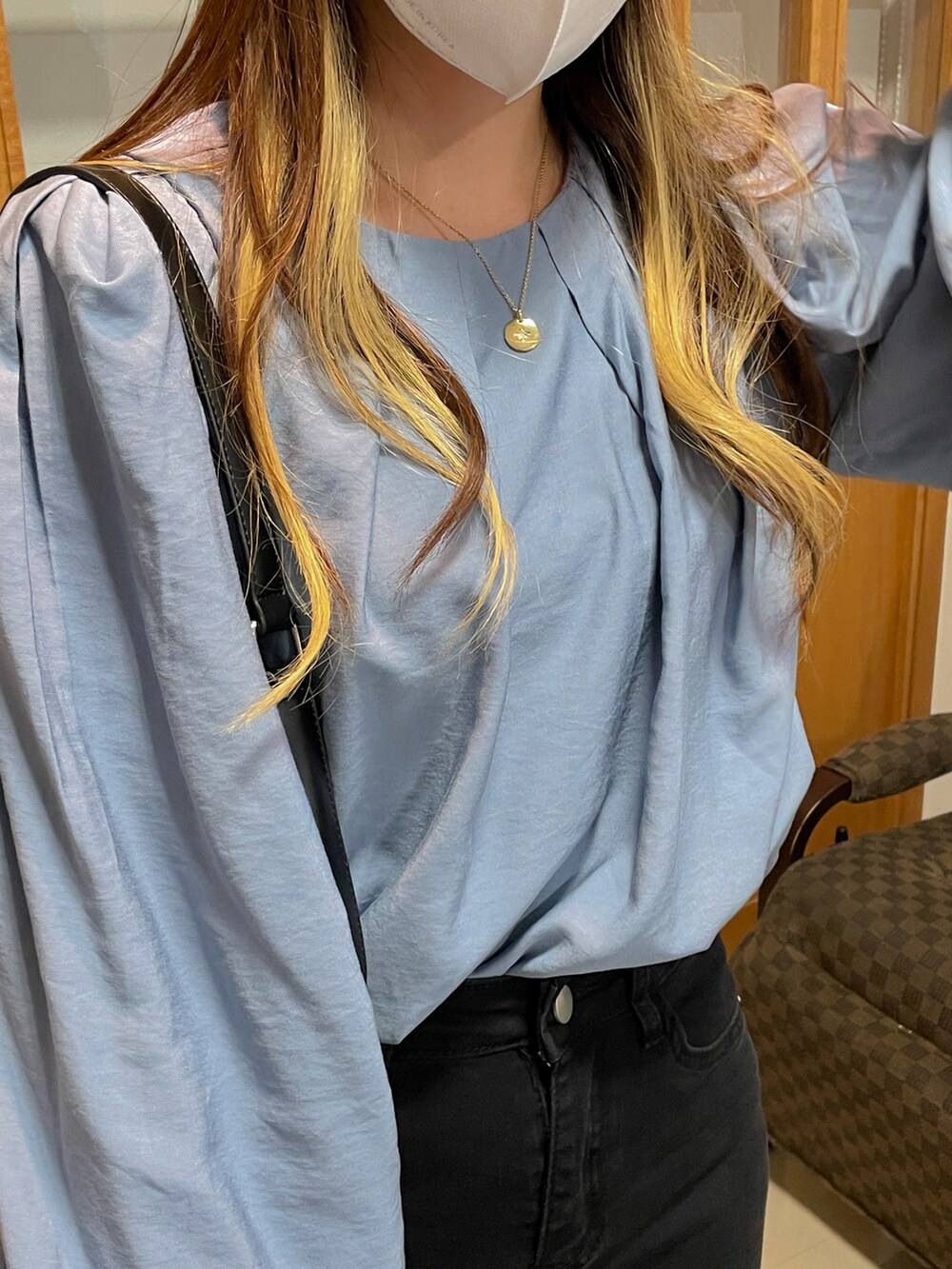 ブラック系のデニムパンツ、ブルー系のシャツ/ブラウス、ブラック系のブーツを着用したレディースの秋コーディネートの3枚目の写真