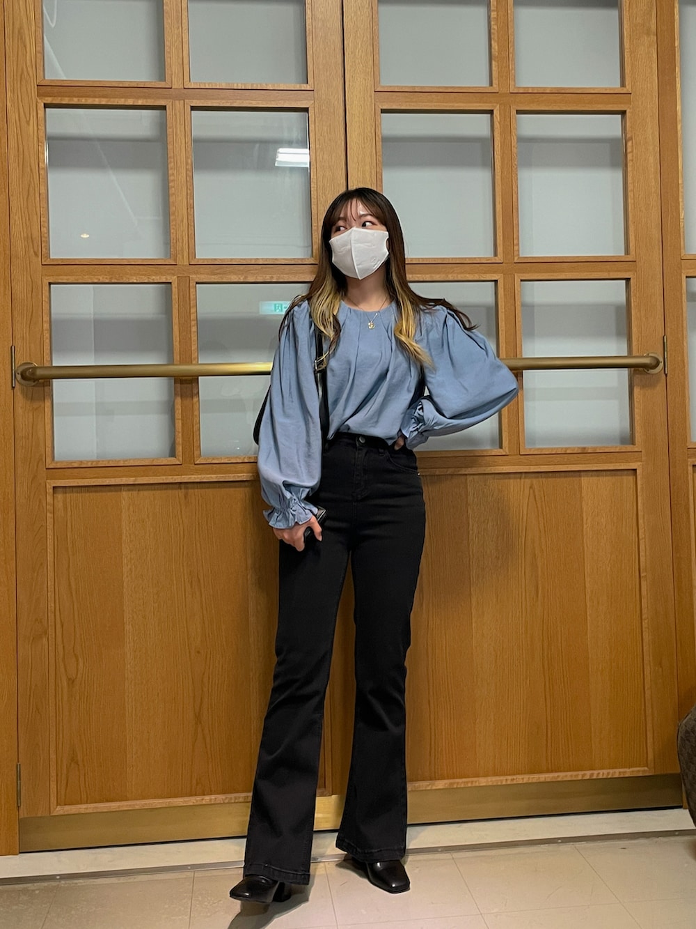 ブラック系のデニムパンツ、ブルー系のシャツ/ブラウス、ブラック系のブーツを着用したレディースの秋コーディネートの2枚目の写真