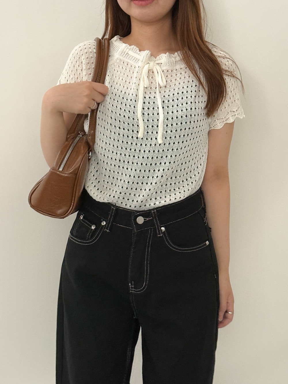 ホワイト系のニット/セーター、ブラック系のデニムパンツ、ブラウン系のショルダーバッグを着用したレディースの夏コーディネートの2枚目の写真