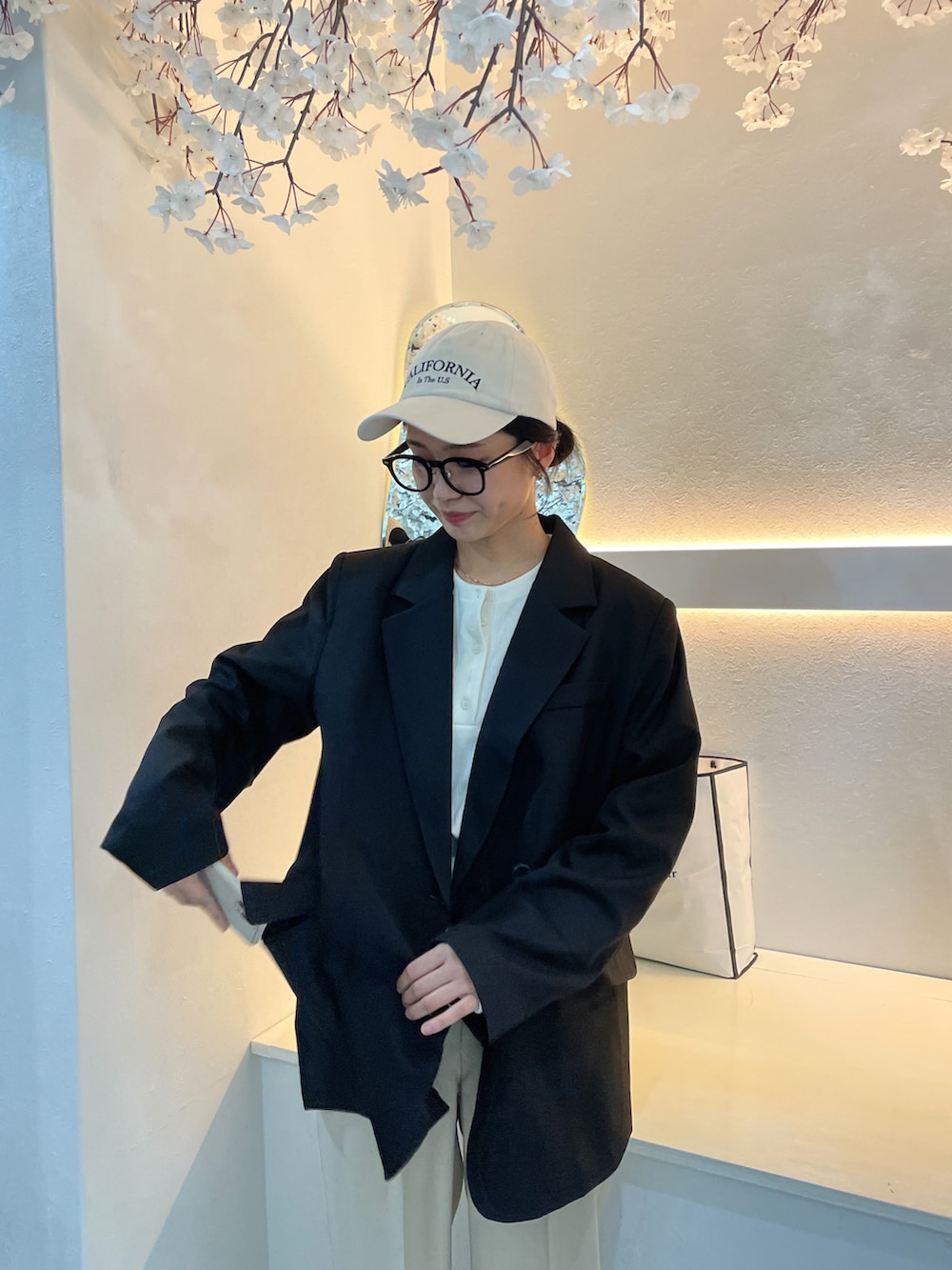 ブラック系のテーラードジャケット、ホワイト系のTシャツ/カットソー、ベージュ系のキャップを着用したレディースの秋コーディネートの2枚目の写真