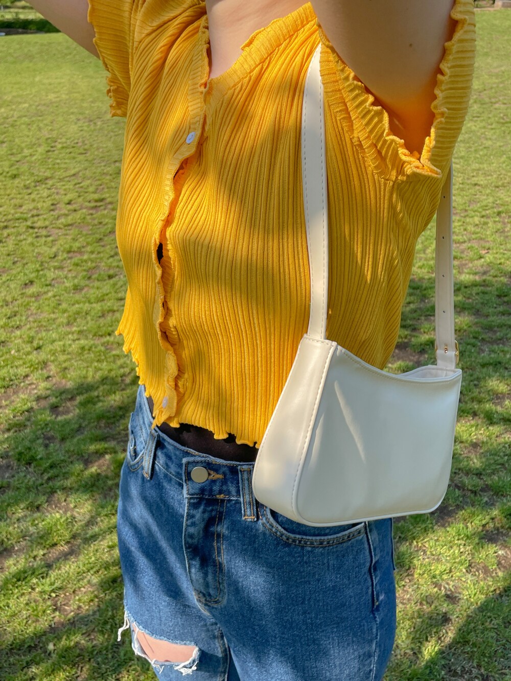 イエロー系のニット/セーター、ブルー系のデニムパンツ、ホワイト系のショルダーバッグを着用したレディースの夏コーディネートの3枚目の写真