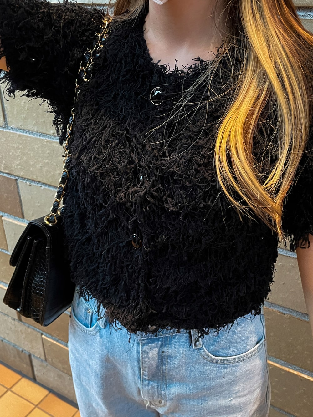 ブルー系のデニムパンツ、ブラック系のシャツ/ブラウス、ブラック系のブーツを着用したレディースの秋コーディネートの3枚目の写真