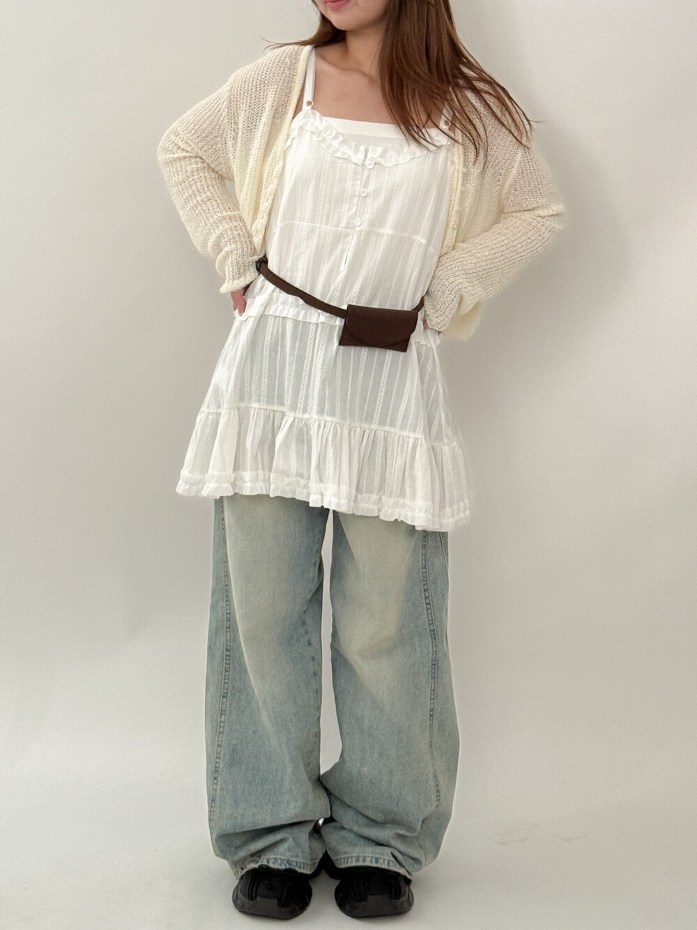 ホワイト系のワンピース、ブルー系のデニムパンツ、ホワイト系のニット/セーターを着用したレディースの夏コーディネートの2枚目の写真