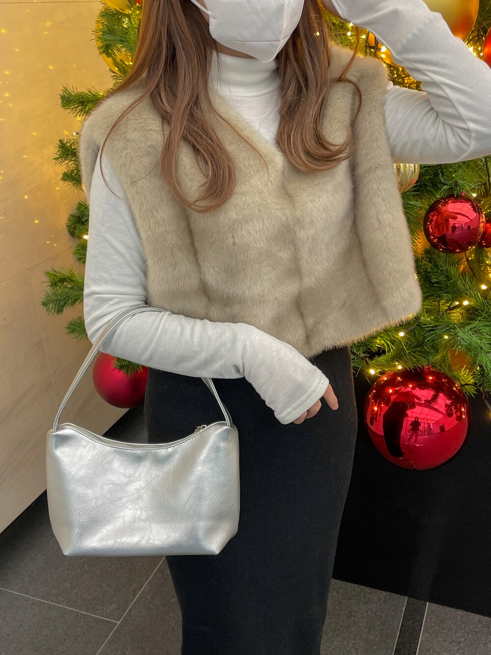 ベージュ系のニット/セーター、シルバー系のショルダーバッグ、ホワイト系のTシャツ/カットソーを着用したレディースの冬コーディネートの3枚目の写真
