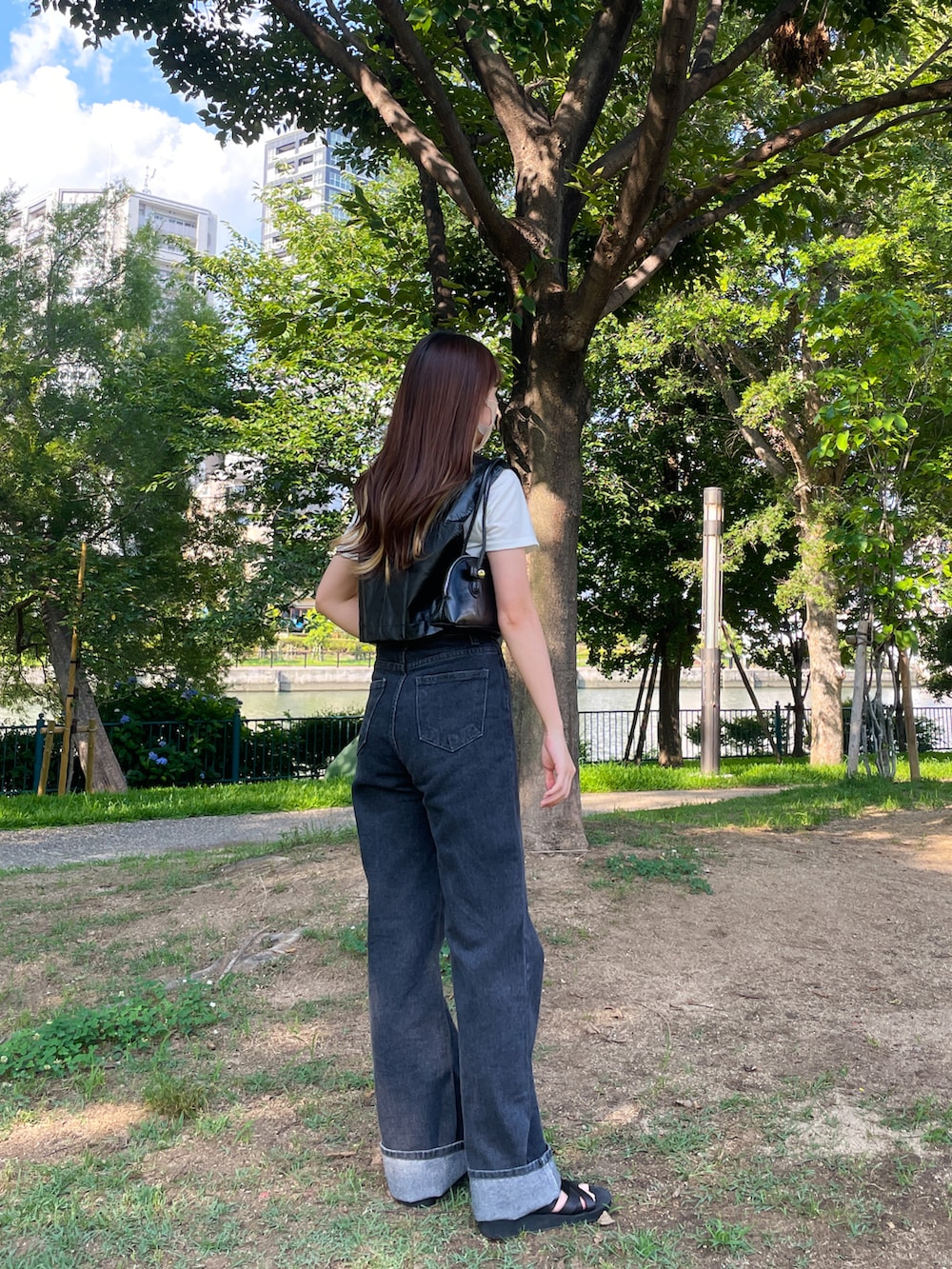 ブラック系のデニムパンツ、ブラック系のテーラードジャケット、ホワイト系のTシャツ/カットソーを着用したレディースの夏コーディネートの2枚目の写真