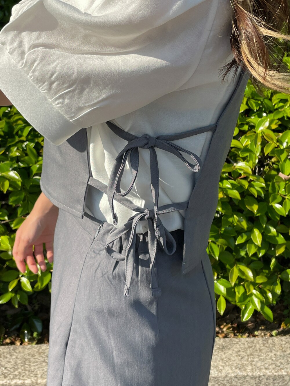 ブラック系のスリッポン、グレー系のワンピース、ホワイト系のシャツ/ブラウスを着用したレディースの春コーディネートの3枚目の写真