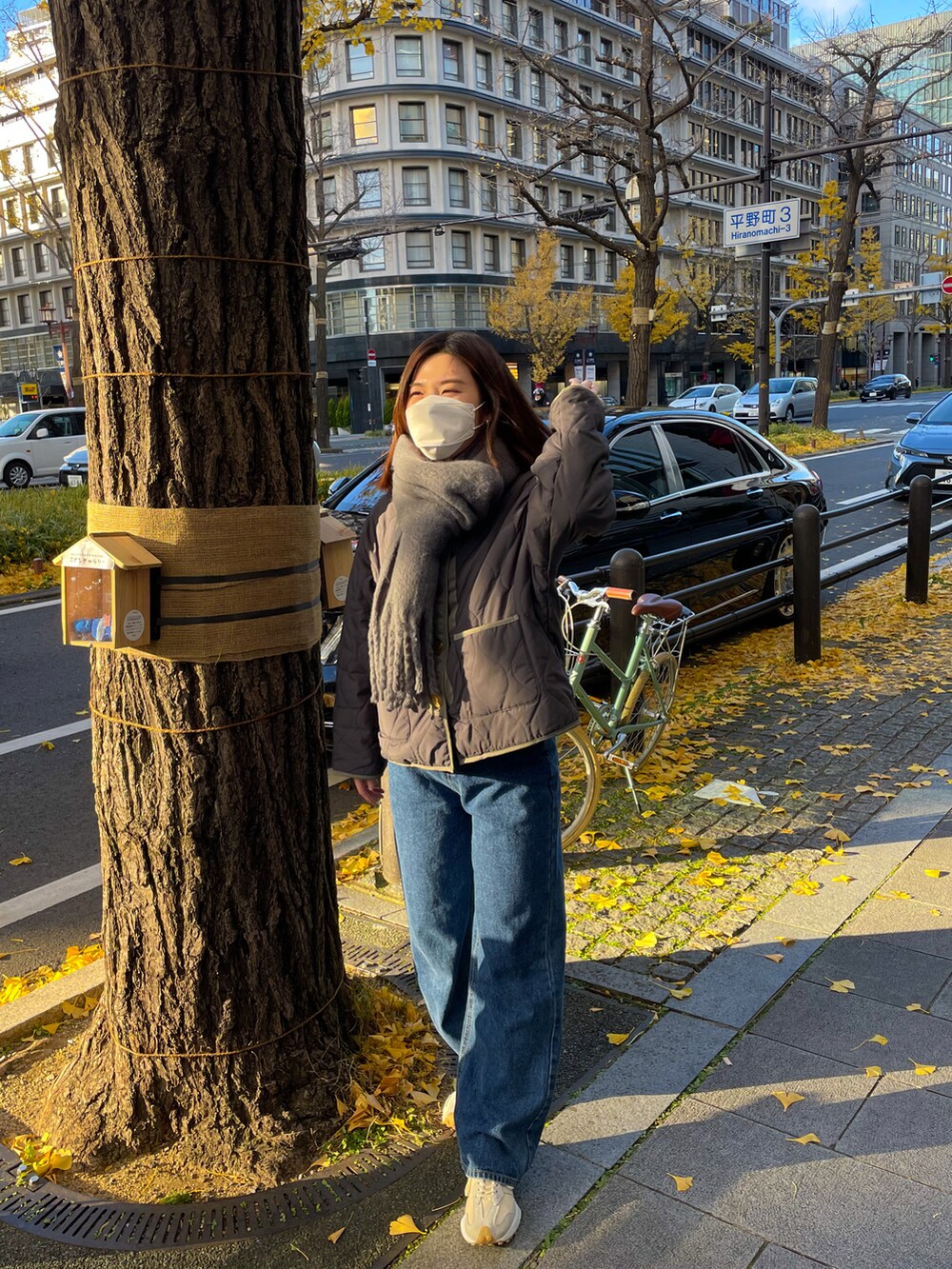 グレー系のテーラードジャケット、ブルー系のデニムパンツ、グレー系のマフラーを着用したレディースの冬コーディネートの2枚目の写真