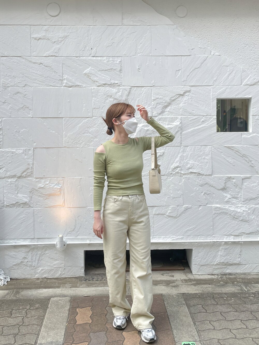 グリーン系のTシャツ/カットソー、ベージュ系のその他パンツ、ホワイト系のショルダーバッグを着用したレディースの春コーディネートの2枚目の写真