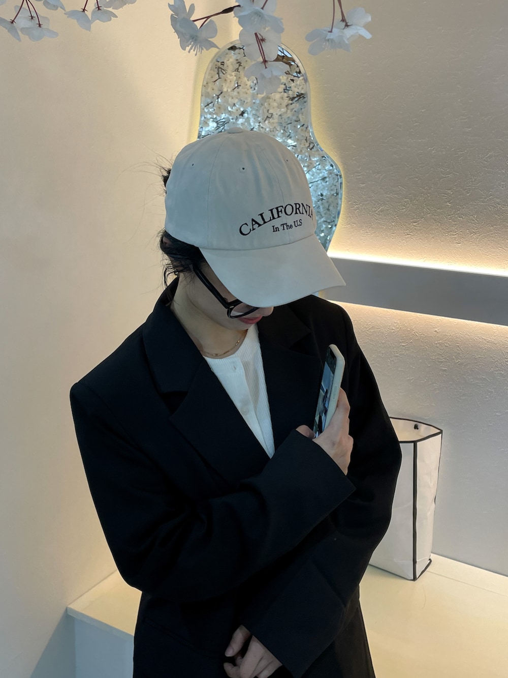 ブラック系のテーラードジャケット、ホワイト系のTシャツ/カットソー、ベージュ系のキャップを着用したレディースの秋コーディネートの3枚目の写真