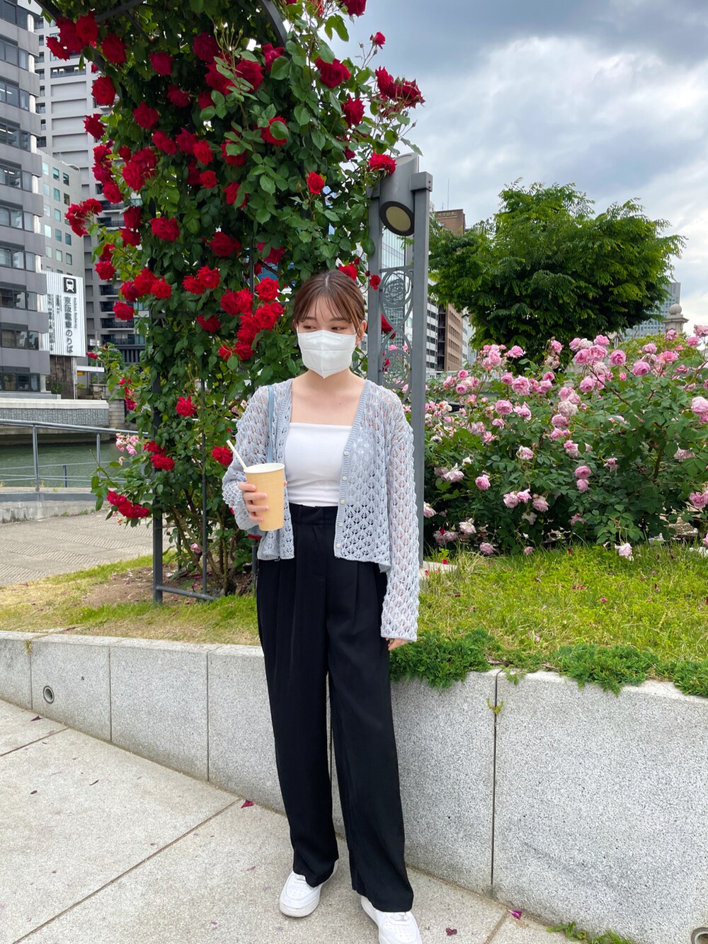 ブルー系のニット/セーター、ブラック系のスラックス、ホワイト系のキャミソールを着用したレディースの春コーディネートの2枚目の写真