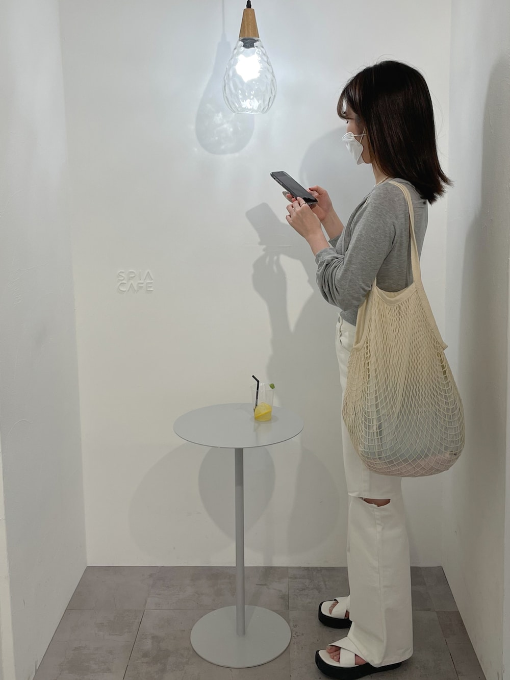 ホワイト系のショルダーバッグ、グレー系のTシャツ/カットソー、ホワイト系のデニムパンツを着用したレディースの春コーディネートの2枚目の写真