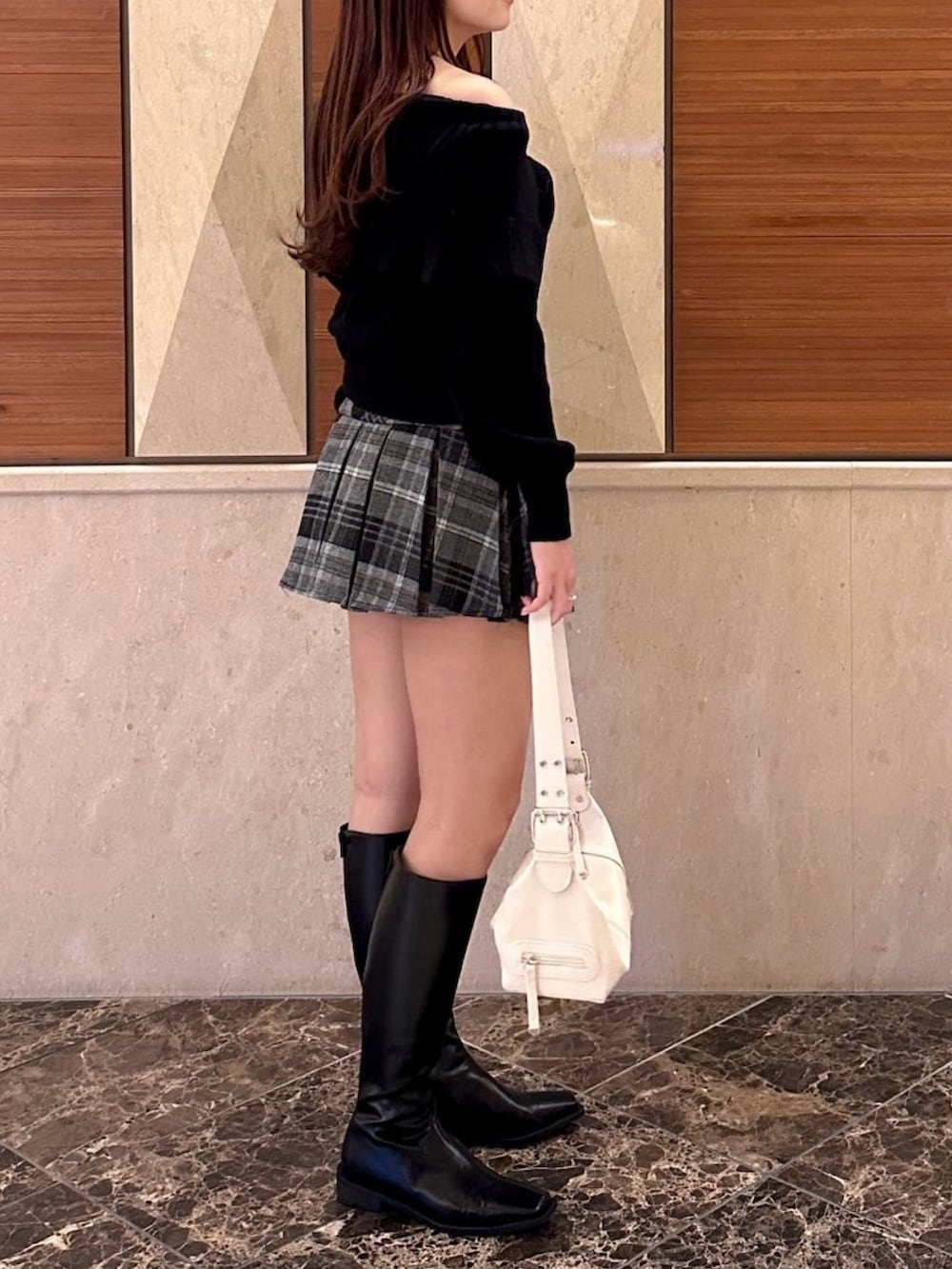 ブラック系のニット/セーター、ブラック系のスカート、ブラック系のブーツを着用したレディースの冬コーディネートの3枚目の写真