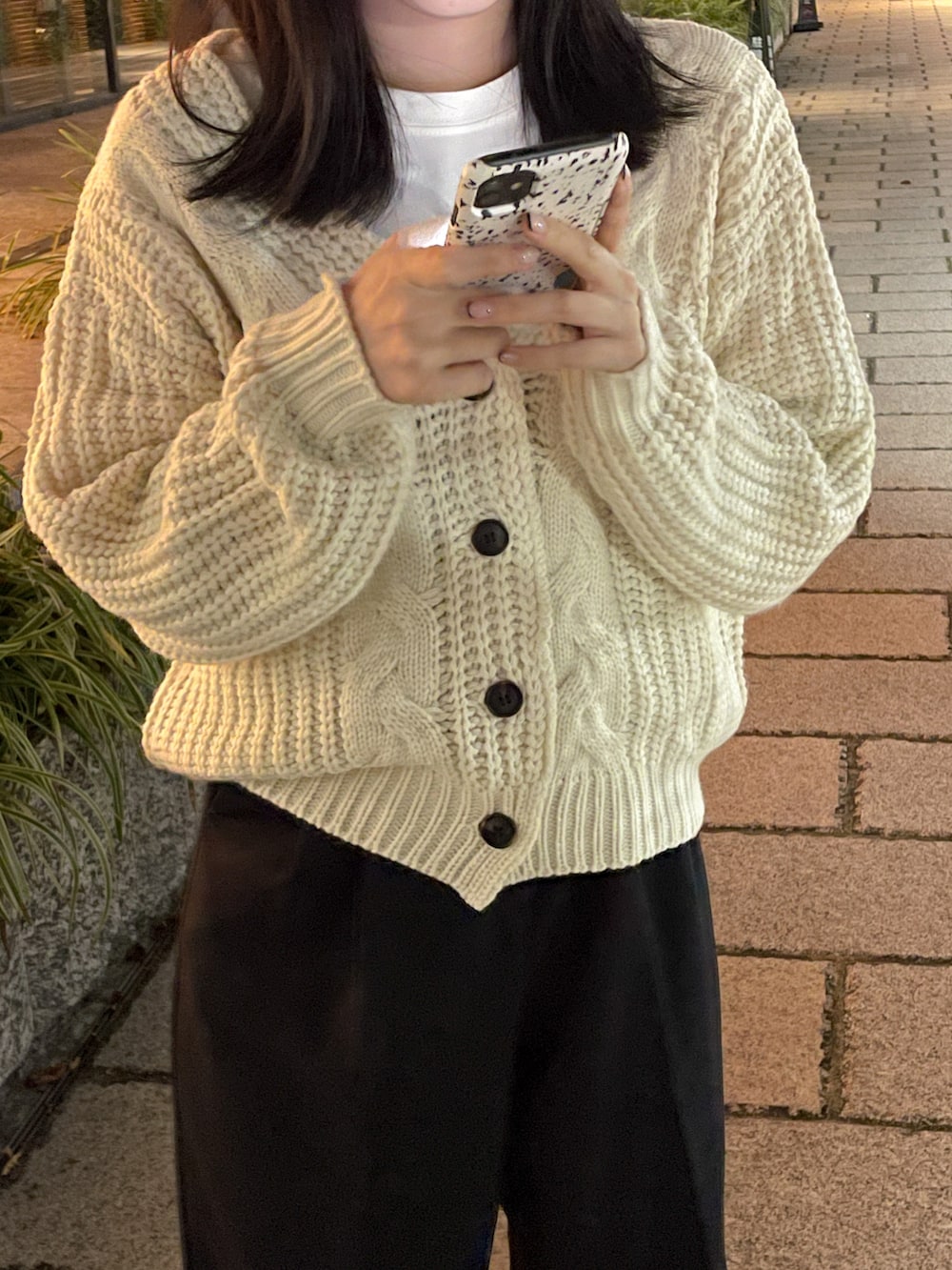 ホワイト系のニット/セーター、ブラック系のスラックスを着用したレディースの秋コーディネートの3枚目の写真