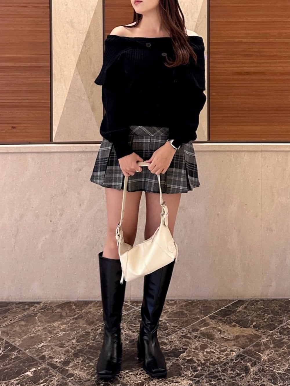 ブラック系のニット/セーター、ブラック系のスカート、ブラック系のブーツを着用したレディースの冬コーディネートの2枚目の写真