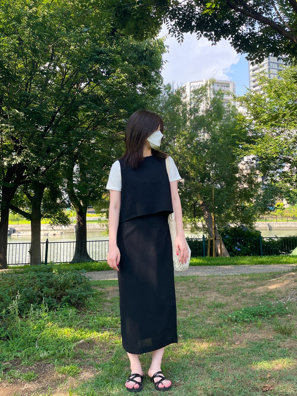 ホワイト系のショルダーバッグ、ホワイト系のTシャツ/カットソー、ブラック系のワンピースを着用したレディースの夏コーディネートの3枚目の写真