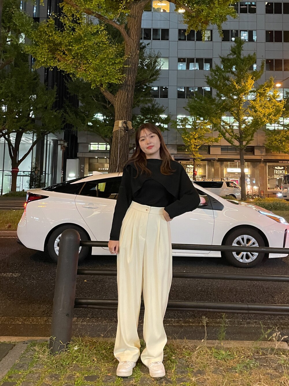 ホワイト系のスラックス、ブラック系のニット/セーターを着用したレディースの秋コーディネートの2枚目の写真