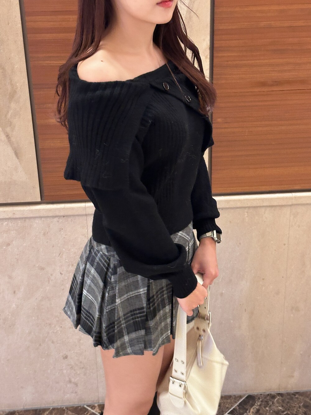 ブラック系のニット/セーター、ブラック系のスカート、ブラック系のブーツを着用したレディースの冬コーディネートの4枚目の写真