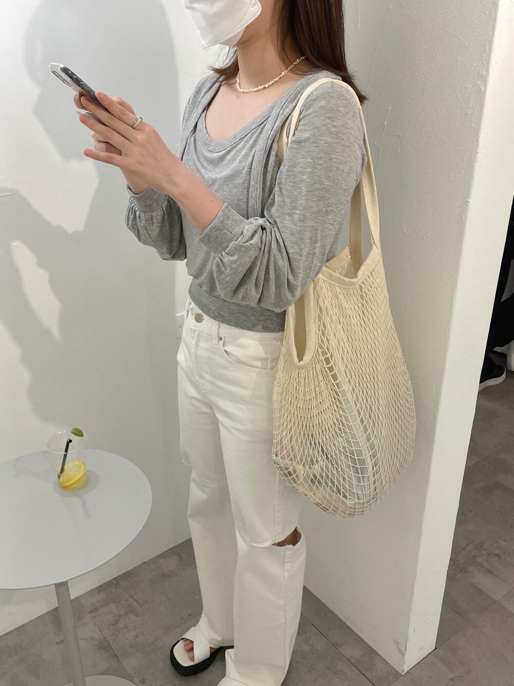 ホワイト系のショルダーバッグ、グレー系のTシャツ/カットソー、ホワイト系のデニムパンツを着用したレディースの春コーディネートの3枚目の写真