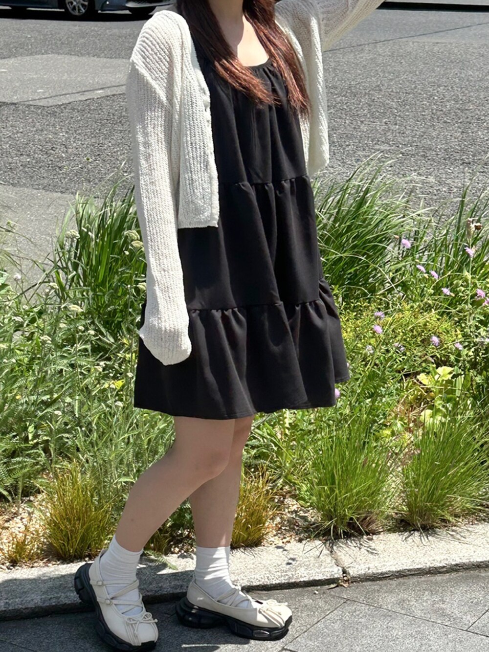 ブラック系のワンピース、ホワイト系のニット/セーター、ホワイト系のスニーカーを着用したレディースの夏コーディネートの2枚目の写真