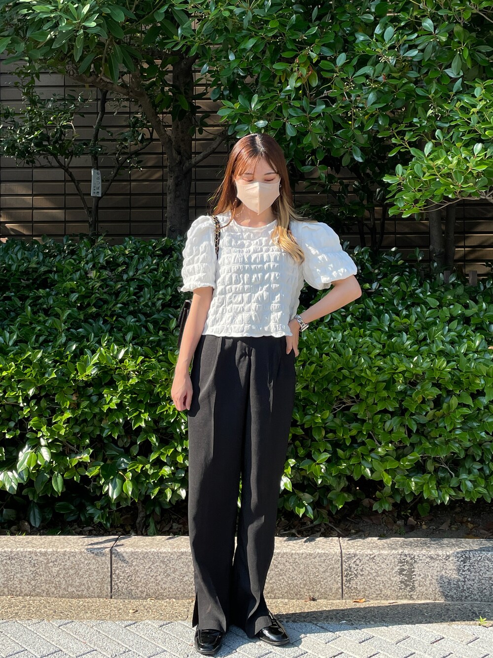 ホワイト系のシャツ/ブラウス、ブラック系のスラックスを着用したレディースの夏コーディネートの2枚目の写真