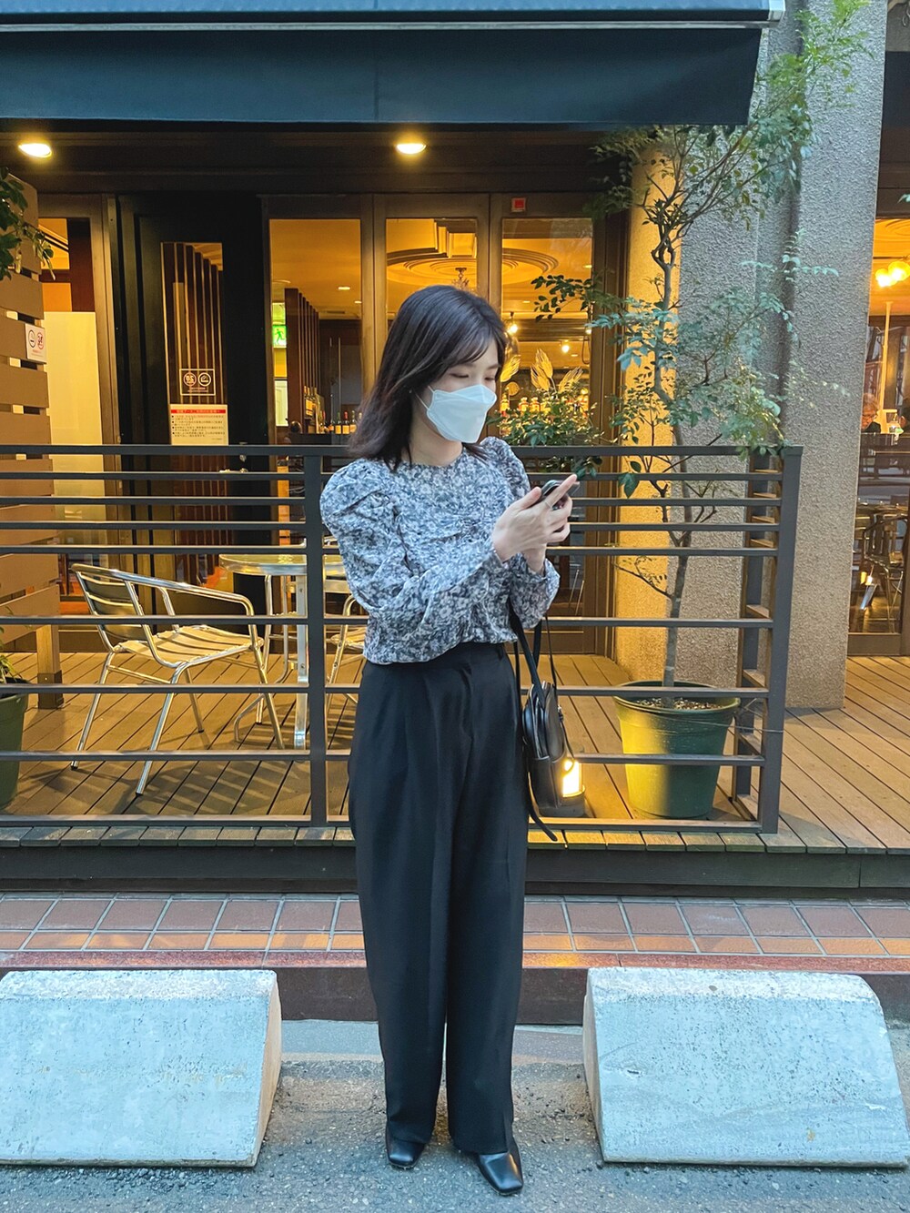 ブラック系のシャツ/ブラウス、ブラック系のスラックスを着用したレディースの春コーディネートの3枚目の写真