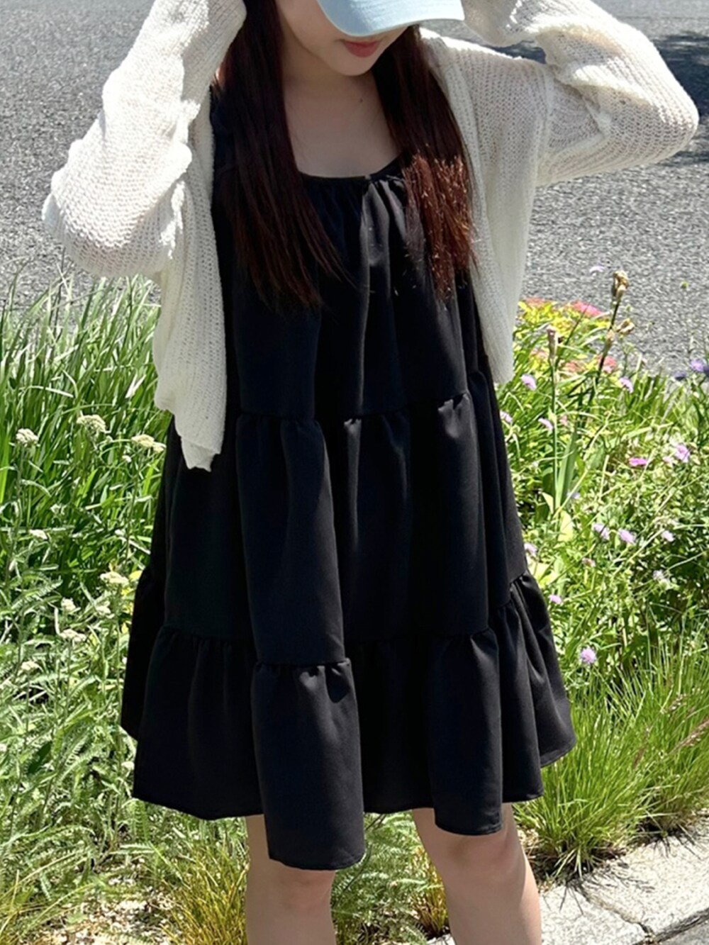 ブラック系のワンピース、ホワイト系のニット/セーター、ホワイト系のスニーカーを着用したレディースの夏コーディネートの3枚目の写真