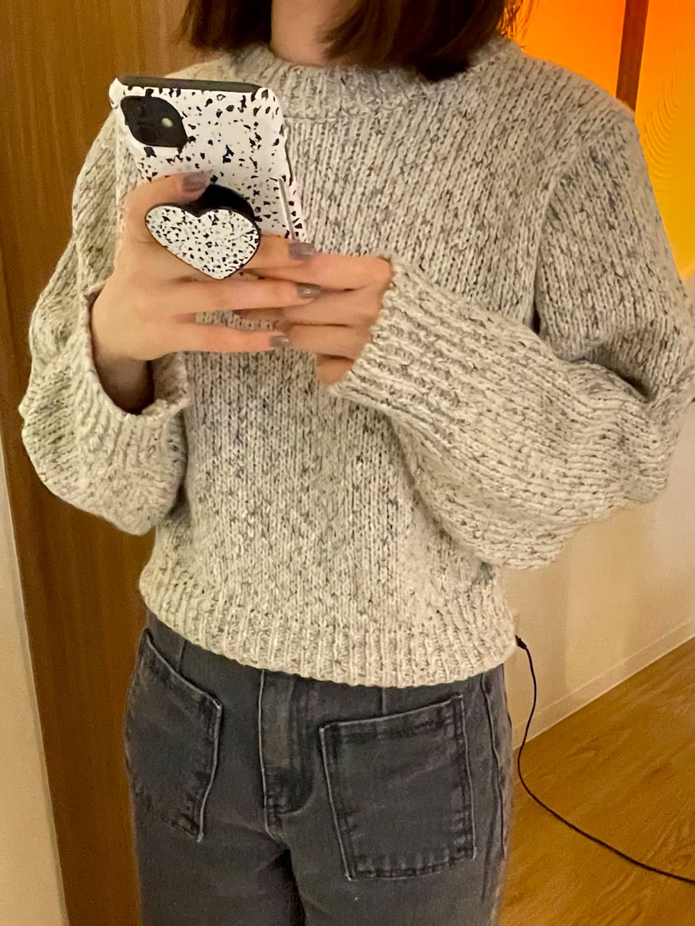 ホワイト系のニット/セーター、グレー系のデニムパンツを着用したレディースの秋コーディネートの2枚目の写真