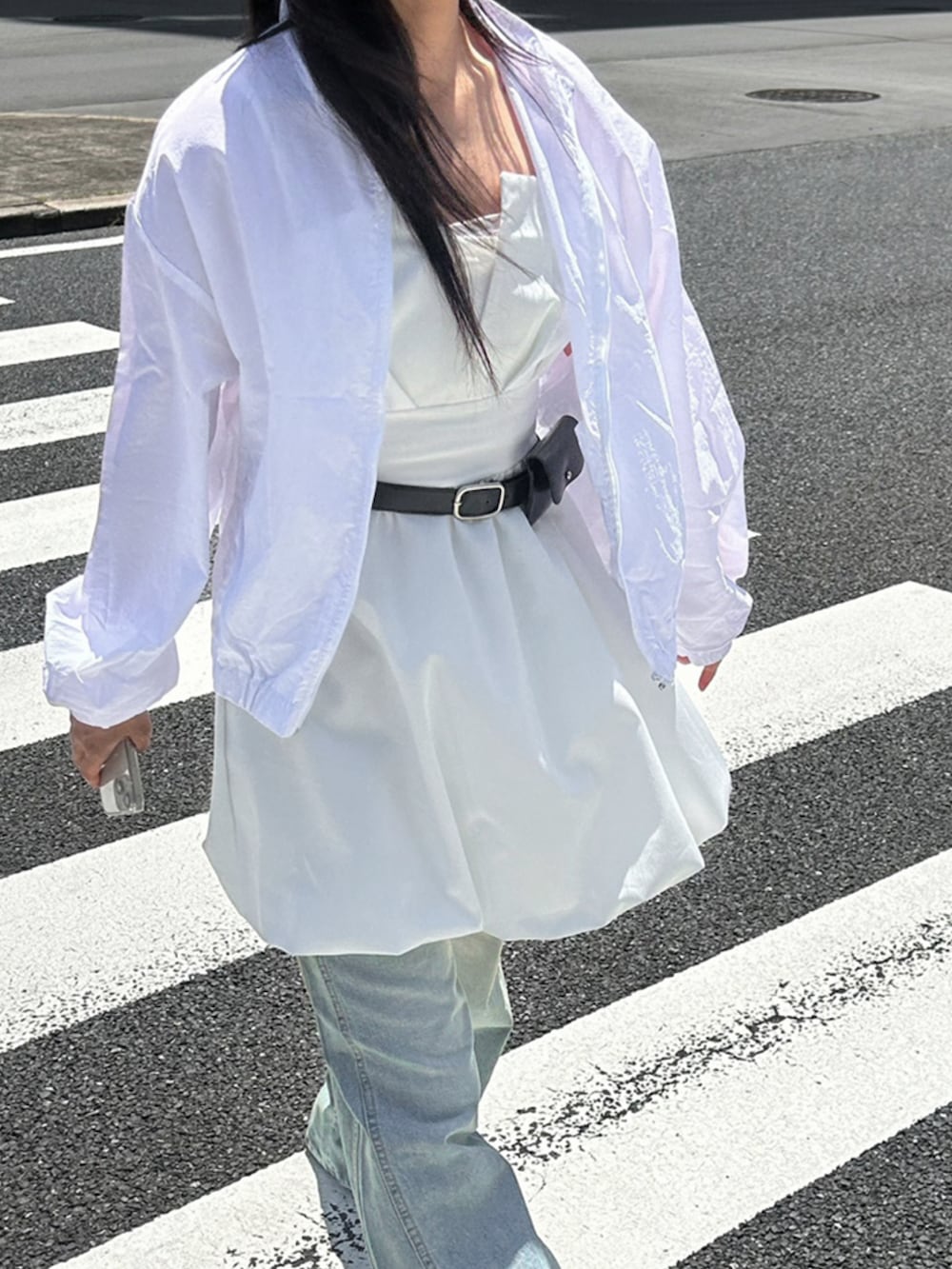 ホワイト系のノーカラージャケット、ホワイト系のワンピース、ブルー系のデニムパンツを着用したレディースの夏コーディネートの4枚目の写真