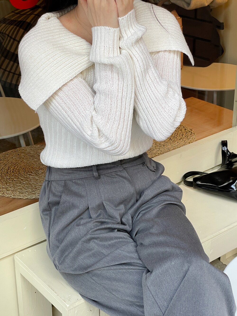 ホワイト系のニット/セーター、グレー系のスラックスを着用したレディースの冬コーディネートの3枚目の写真