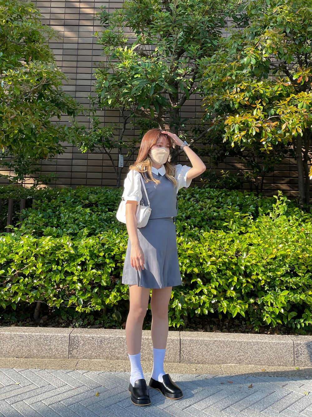 ブラック系のスリッポン、グレー系のワンピース、ホワイト系のシャツ/ブラウスを着用したレディースの春コーディネートの2枚目の写真