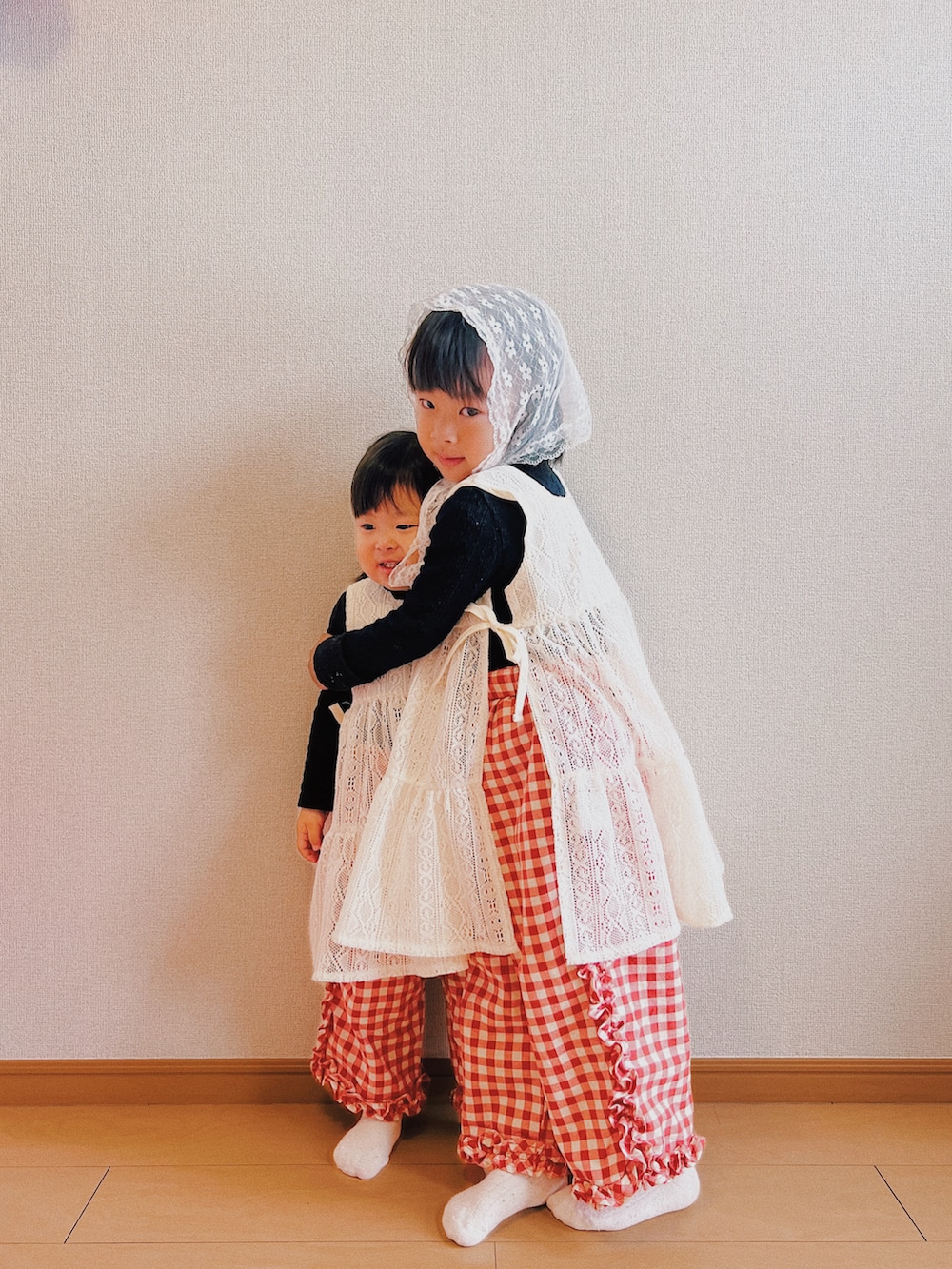 ホワイト系のワンピース/ドレス、レッド系のその他パンツ、レッド系のその他パンツを着用したキッズの冬コーディネートの2枚目の写真