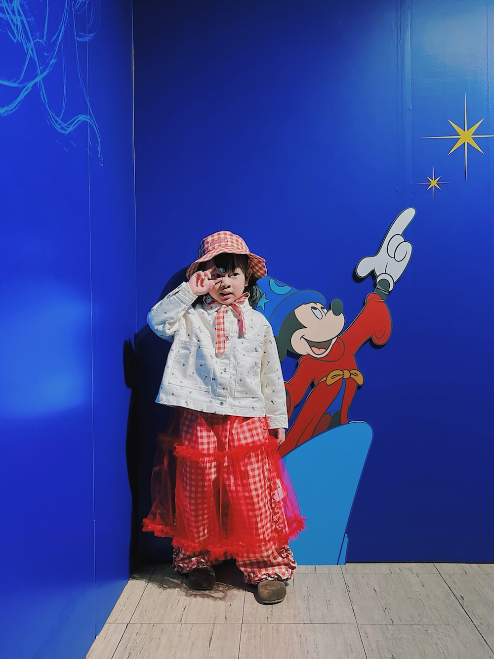 レッド系のワンピース、レッド系のその他パンツ、ホワイト系のデニムジャケットを着用したキッズの春コーディネートの2枚目の写真