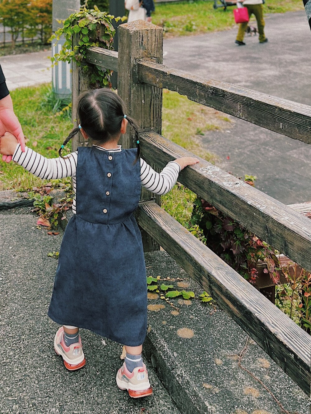 ブルー系のワンピース、ホワイト系のTシャツ/カットソー、ピンク系のスニーカーを着用したキッズの秋コーディネートの2枚目の写真