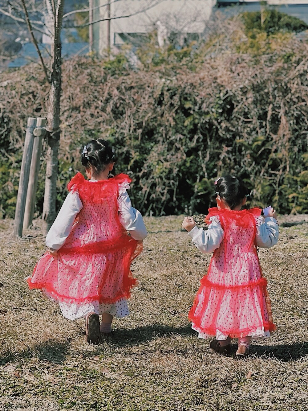 レッド系のワンピースを着用したキッズの春コーディネートの2枚目の写真