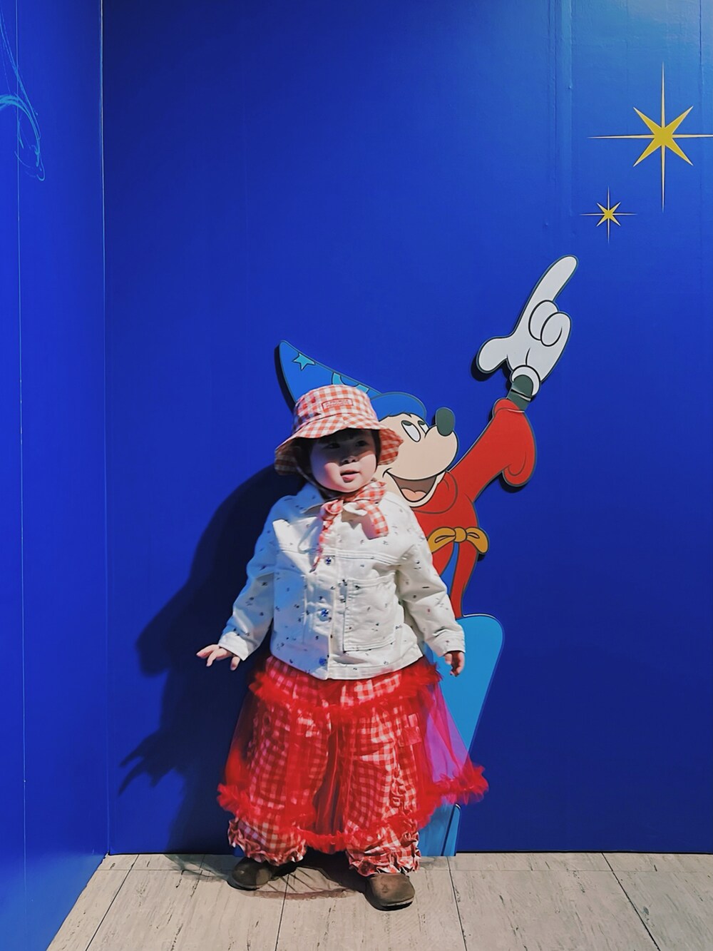 レッド系のワンピース、レッド系のその他パンツ、ホワイト系のデニムジャケットを着用したキッズの春コーディネートの3枚目の写真