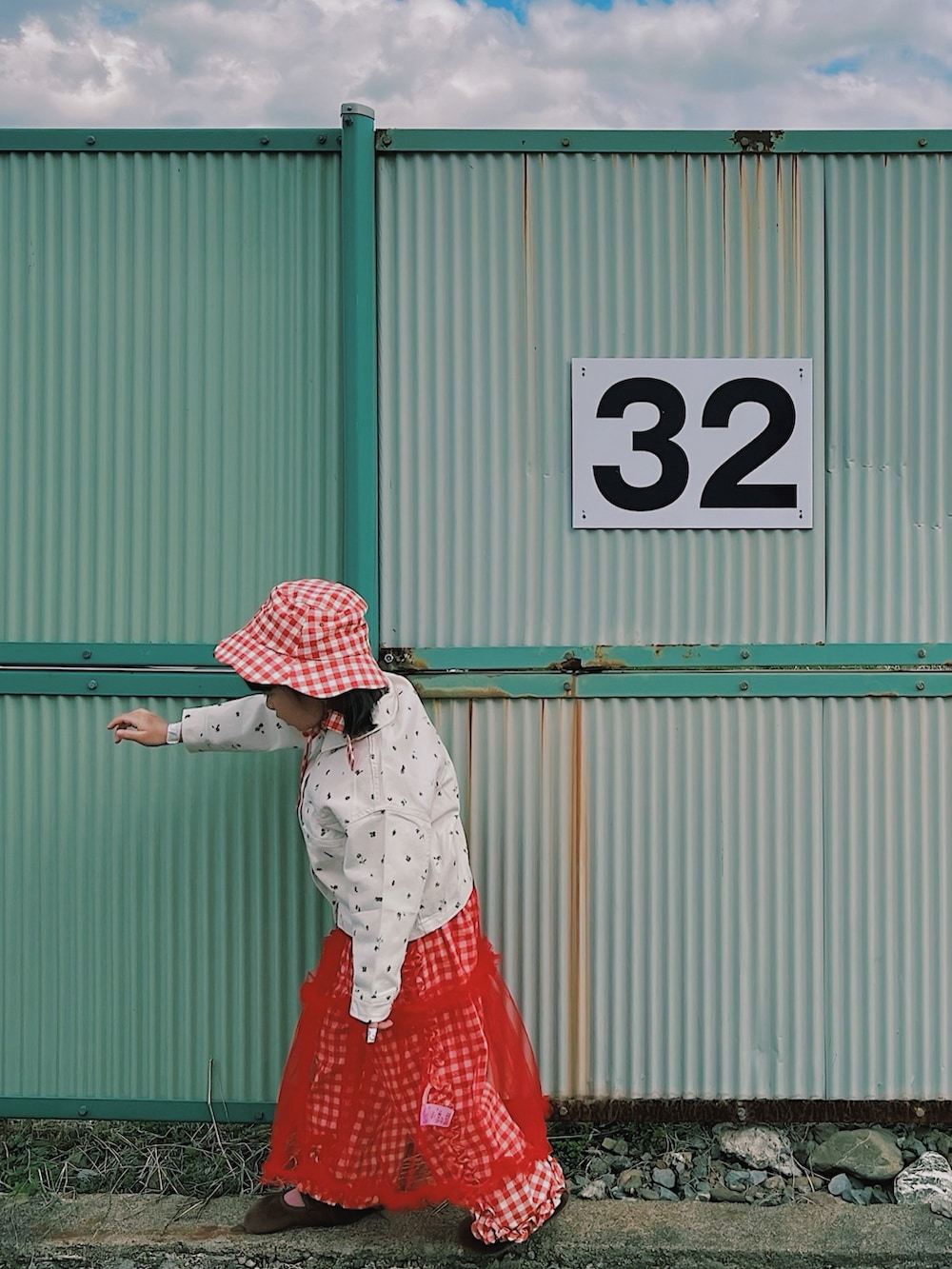 レッド系のワンピース、レッド系のその他パンツ、ホワイト系のデニムジャケットを着用したキッズの春コーディネートの4枚目の写真